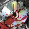 Bloody Toilet Bowl – HAM HOLE HAM HOLE: Close-up of a blood-smeared CD with a black center hole on a gray surface.