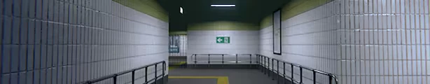 Metrophobia: Empty tiled metro corridor with railings, exit sign, and blank poster frame.