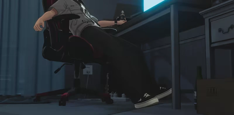 Gaming Desk Chair – Ved: Recure Ved: Person slumped in gaming chair at desk, monitor glowing blue, sneakers visible.
